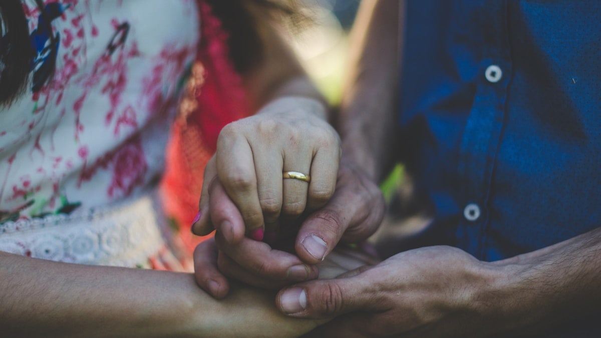 person in blue shirt holding hands